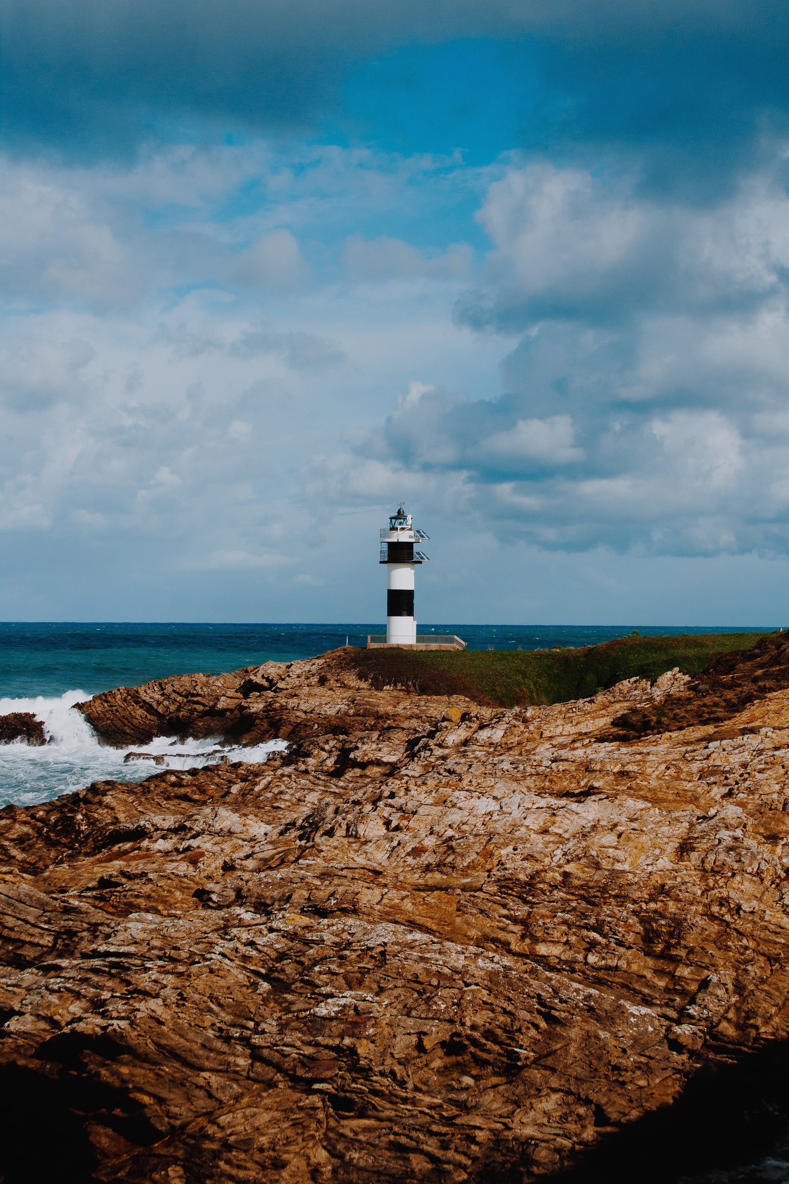 Striped lighthouse on the rocks out to sea
